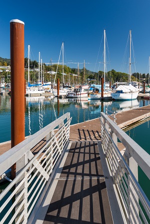 A dock walkway leads to a view of boats in the Brookings Harbor.