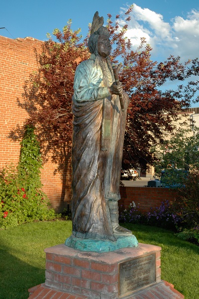 Life‑size bronze statue of Chief Joseph, standing in traditional attire, installed outdoors.