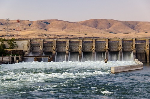 A hydropower dam in The Dalles consists of a concrete structure with a navigation lock, spillway, gated powerhouse & fish passage facilities.