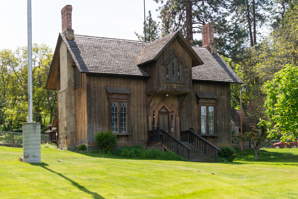Historic two‑story Gothic Revival building—the 1856 Surgeon’s Quarters of Fort Dalles—featuring pointed gables and board‑and‑batten siding