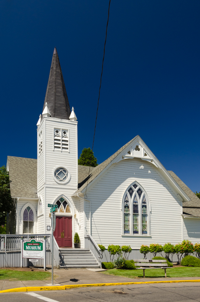 Originaly a Methodist-Episcopal Church built in 1889, this building has a stair leading to double doors and a steeple.