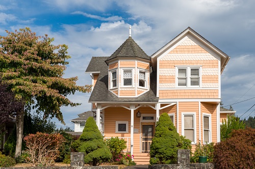 A 2-story, single-family Victorian-era home built circa 1900–1905, featuring an asymmetrical Queen Anne–style design with intersecting gables, variegated shingle patterns, and cornerboards on its wood-clad exterior