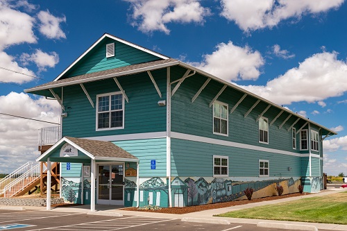 Rectangular, wood frame building. Gable roof with brackets. Shiplap siding.