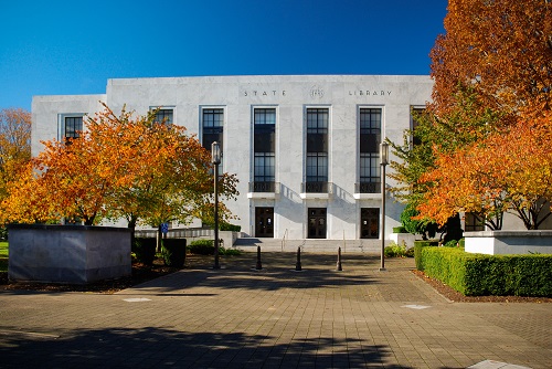 Front exterior of the Oregon State Library building at 250 Winter St NE in Salem—a rectangular, two‑story, classical-style structure with tall windows.