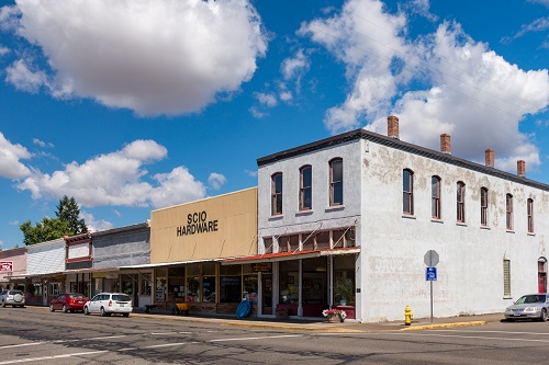 Street view of commercial business buildings in downtown Scio. One building says 