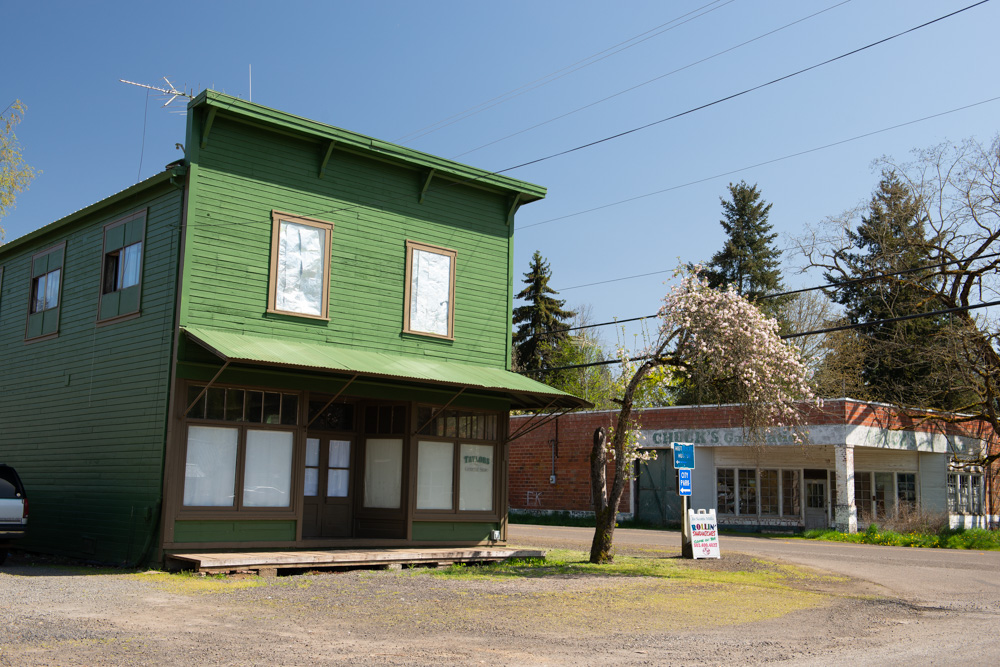 Historic downtown Scotts Mills, featuring a row of early 20th‑century storefronts, wood‑framed, pitched‑roof buildings with awnings.