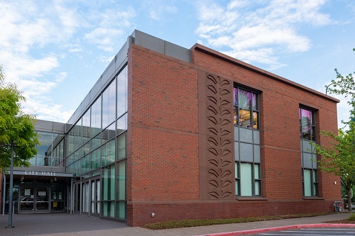 A 2 story building with brick walls on one side and windows on the other.
