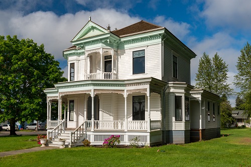 Queen Anne Style house. Stone foundation, wood walls, shingle roof. Two-story wood structure built in 1902-03. The asymmetrical structure dominates a corner lot with a wrap-around porch and ornamental gabled dormer with bell shaped walls and patterned shingles decorating roof.