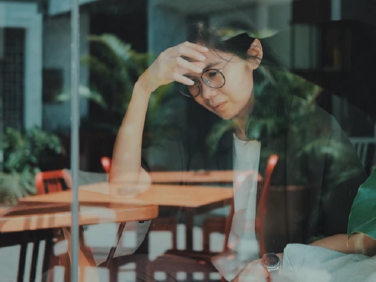 Woman thinking and looking at computer screen.
