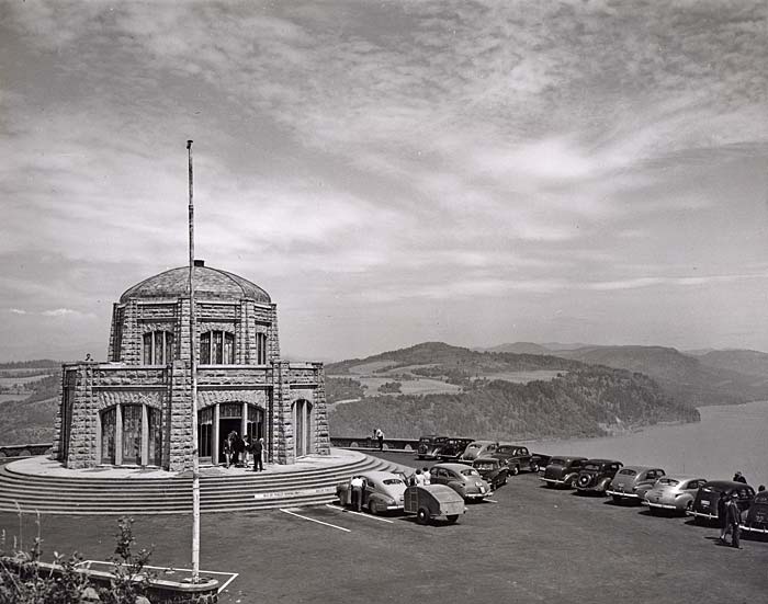 A domed stone building sits a top a high cliff looking over the Columbia Gorge. 