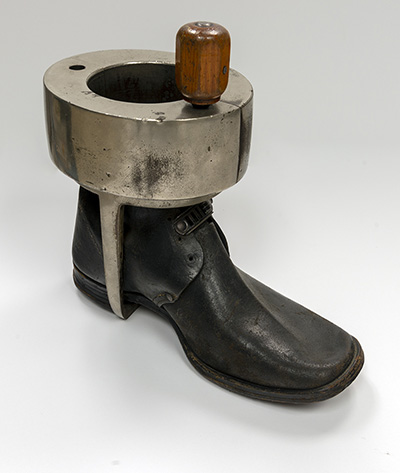 A boot with a metal brace fitting around the ankle and hooked under the heal.