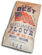 A sack with an American flag & the words "The Best Hard wheat Flour, P.D. & M. Co. Grant, Oregon."