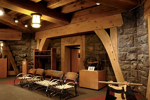 The lobby of Timberline lodge with walls made of large stone slabs. Rustic wooden furnishings built during the Depression.
