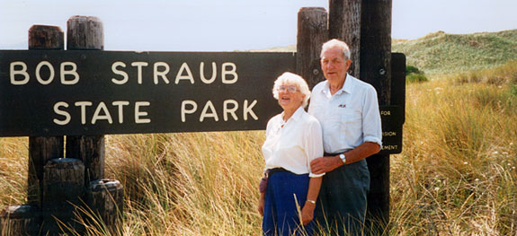 Bob Straub & his wife stand before a sign reading "Bob Straub State Park."