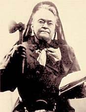 photograph of Carrie Nation holding a hatchet in one hand and the Bible in the other 