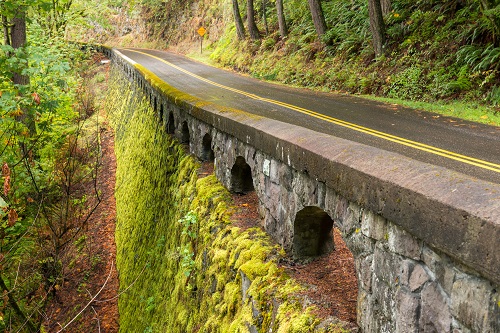scenic highway with moss covered rock railing