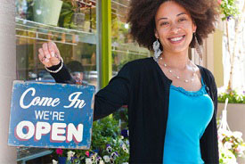 Woman holding "Open" sign